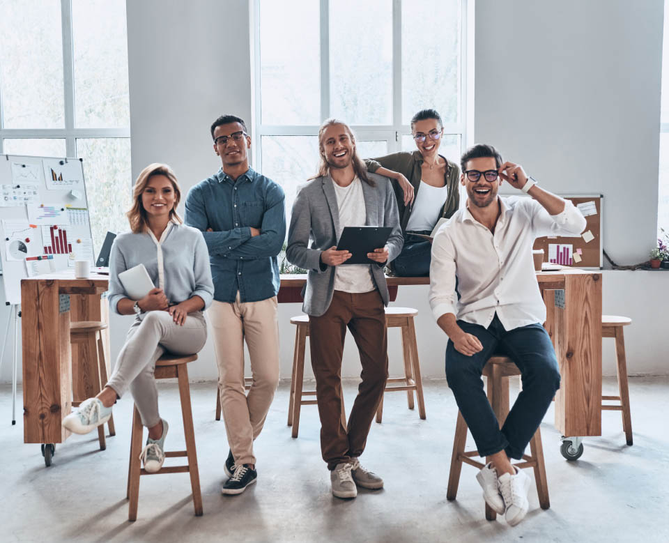 Successful professionals. Full length of young modern people in smart casual wear smiling and looking at camera while standing in the creative office